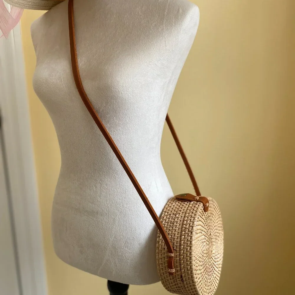 Round solid rattan woven crossbody purse cloth lined, leather accents.